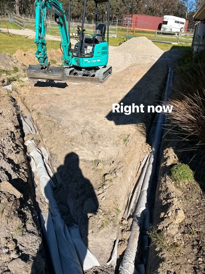 Mini excavator digging a drainage trench